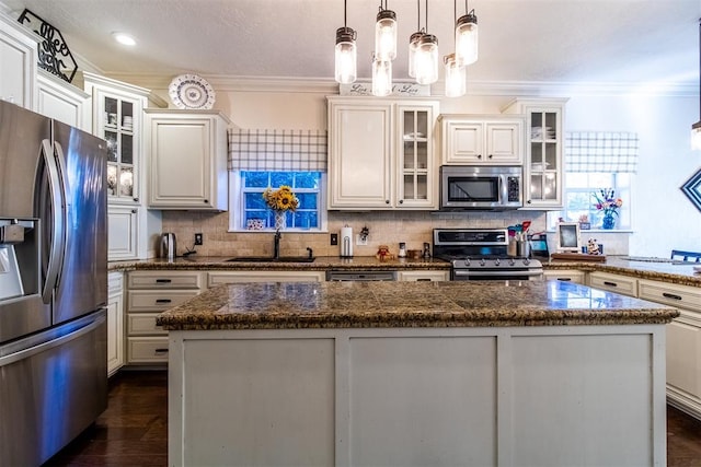 kitchen with a center island, decorative light fixtures, dark hardwood / wood-style flooring, white cabinetry, and stainless steel appliances