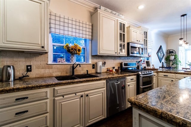 kitchen with sink, backsplash, decorative light fixtures, appliances with stainless steel finishes, and ornamental molding