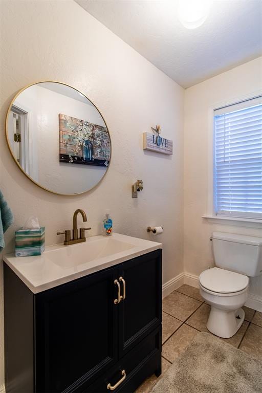 bathroom with tile patterned flooring, vanity, and toilet