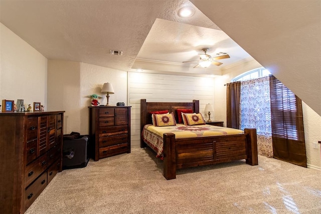 carpeted bedroom with a textured ceiling, ceiling fan, and ornamental molding