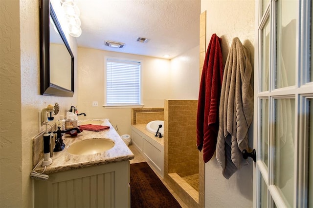 bathroom with independent shower and bath, vanity, wood-type flooring, and a textured ceiling