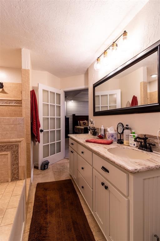 bathroom featuring tile patterned floors, vanity, and a textured ceiling