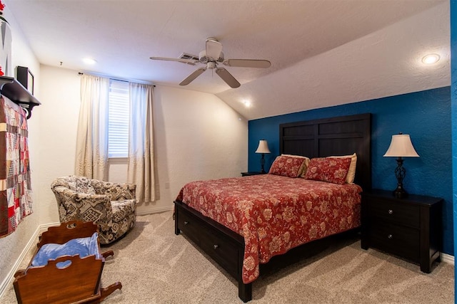 bedroom with ceiling fan, light colored carpet, and vaulted ceiling