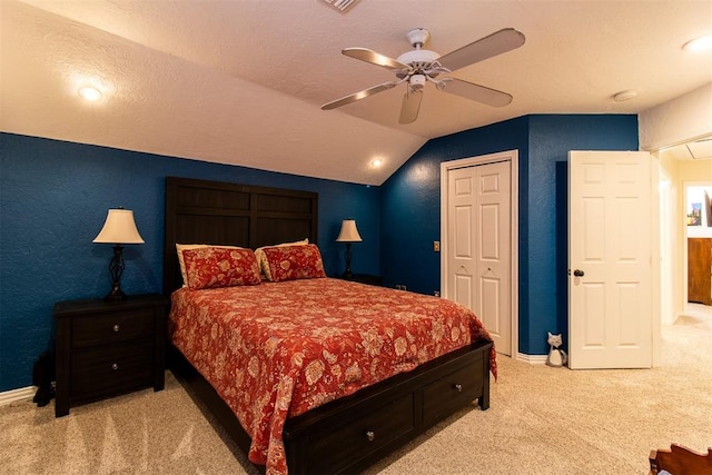 bedroom with light carpet, a textured ceiling, vaulted ceiling, and ceiling fan