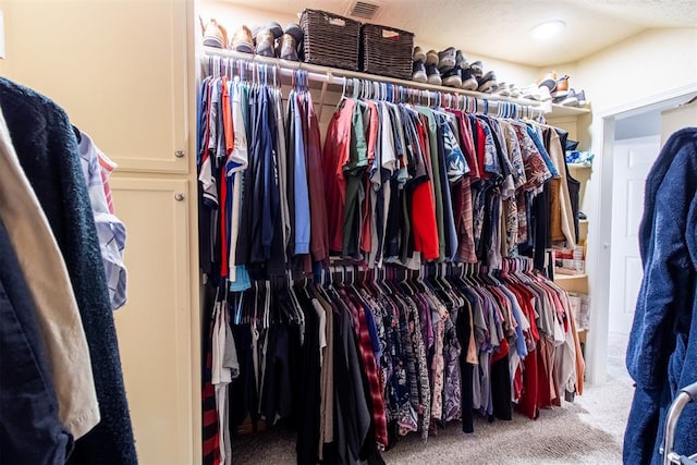 walk in closet featuring carpet flooring