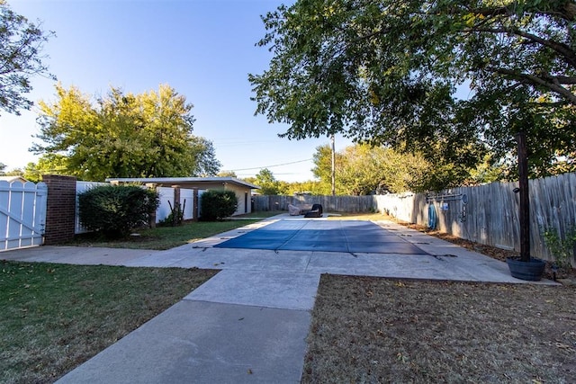 view of swimming pool featuring a patio area and a yard