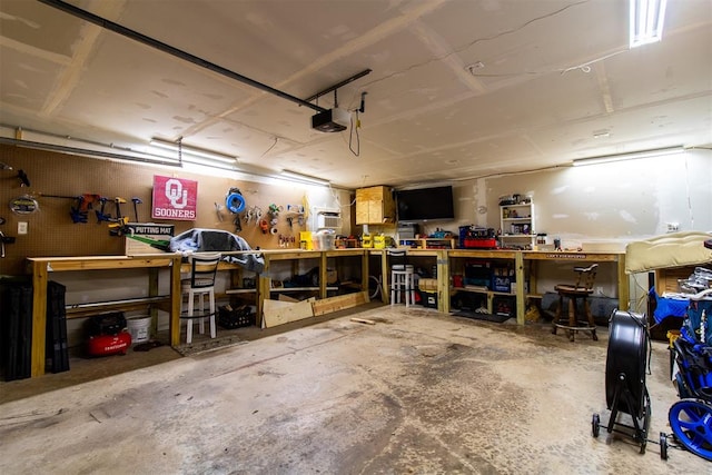 garage with a workshop area and a garage door opener