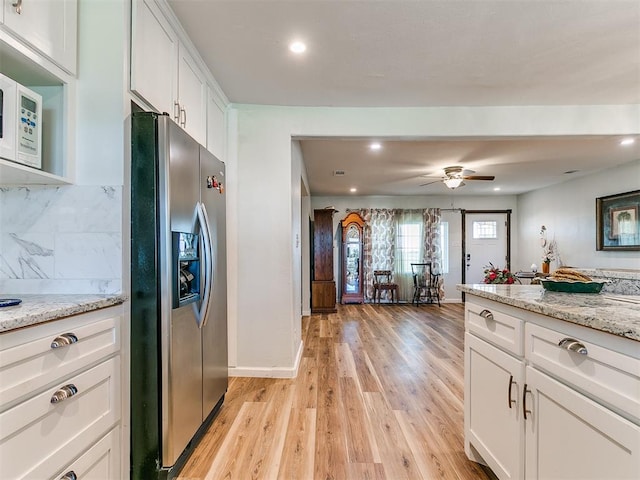 kitchen featuring stainless steel fridge with ice dispenser, light hardwood / wood-style floors, white cabinetry, and light stone counters