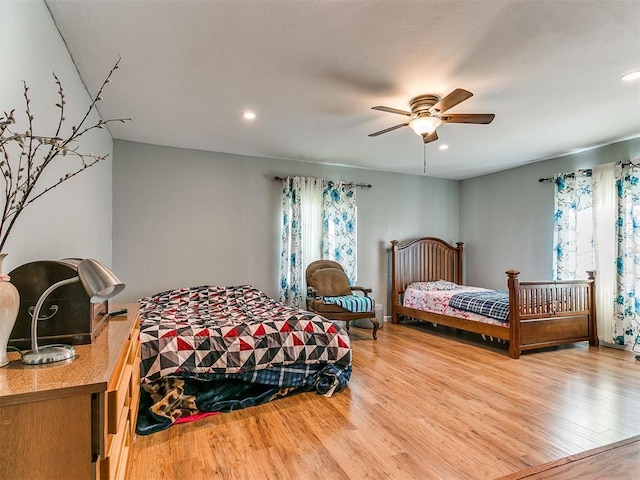 bedroom with hardwood / wood-style floors, ceiling fan, and multiple windows