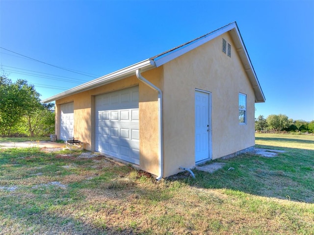 view of side of property featuring a yard, an outdoor structure, and a garage