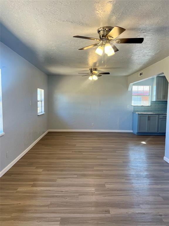 spare room with ceiling fan, a textured ceiling, and hardwood / wood-style flooring