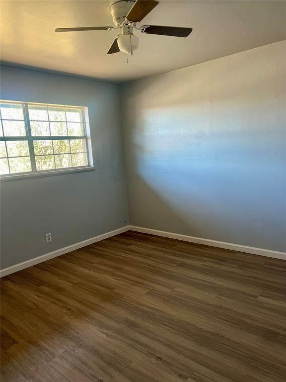 spare room with ceiling fan and dark wood-type flooring