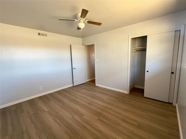 unfurnished bedroom featuring wood-type flooring, a closet, and ceiling fan