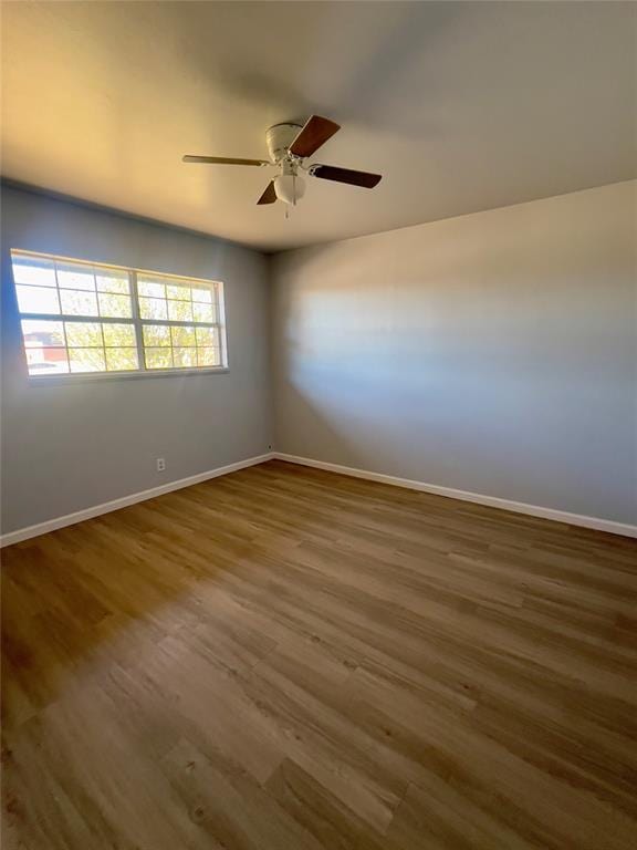 empty room with dark hardwood / wood-style floors and ceiling fan