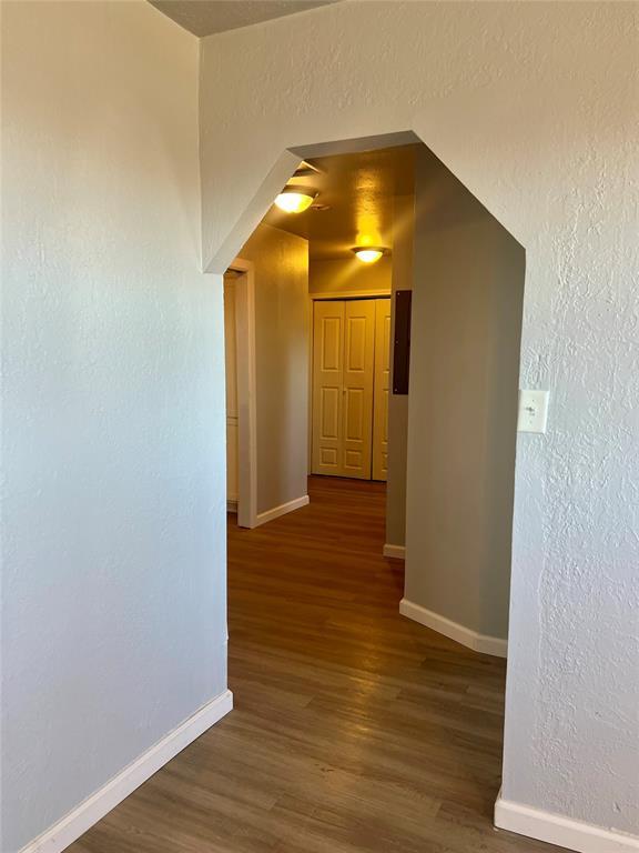 corridor with hardwood / wood-style flooring