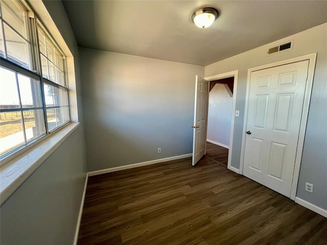 unfurnished bedroom featuring dark hardwood / wood-style flooring