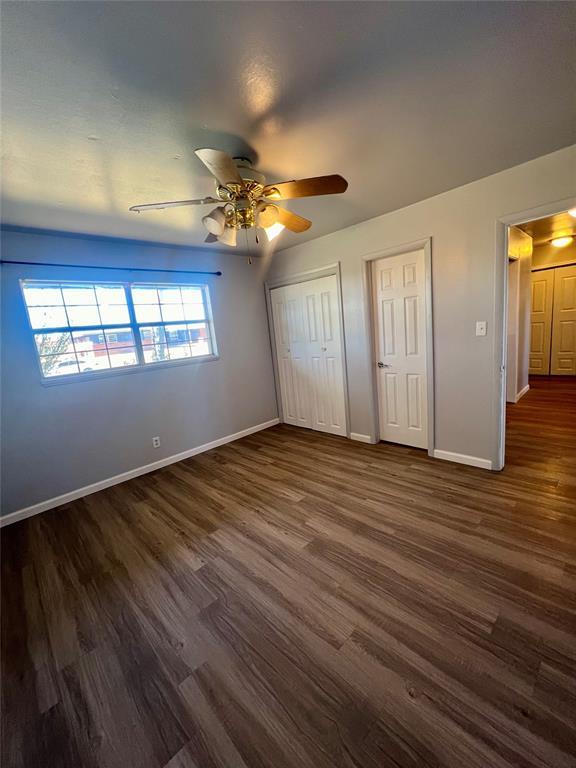 unfurnished bedroom with dark hardwood / wood-style flooring and ceiling fan