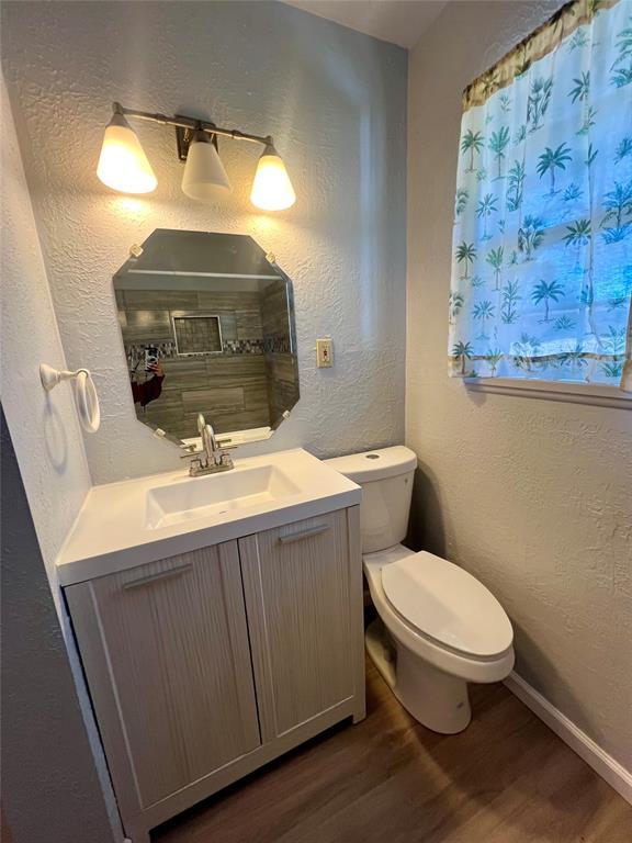 bathroom featuring wood-type flooring, vanity, and toilet