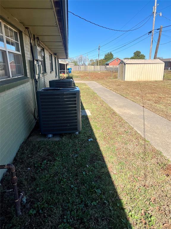 view of yard with cooling unit and a storage shed