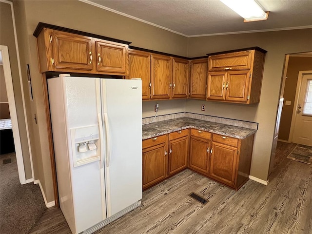 kitchen with a textured ceiling, crown molding, light hardwood / wood-style floors, and white refrigerator with ice dispenser