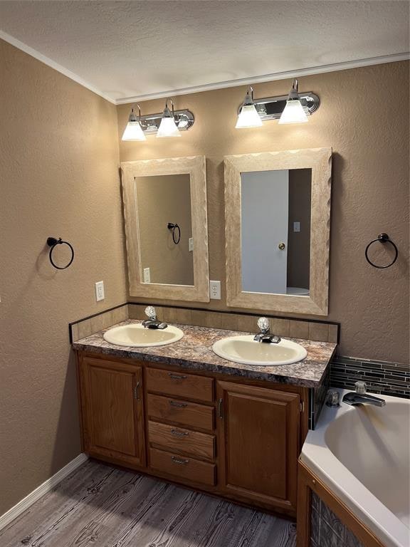 bathroom featuring hardwood / wood-style floors, vanity, a bathtub, and crown molding