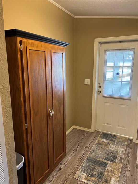 doorway featuring hardwood / wood-style floors and ornamental molding