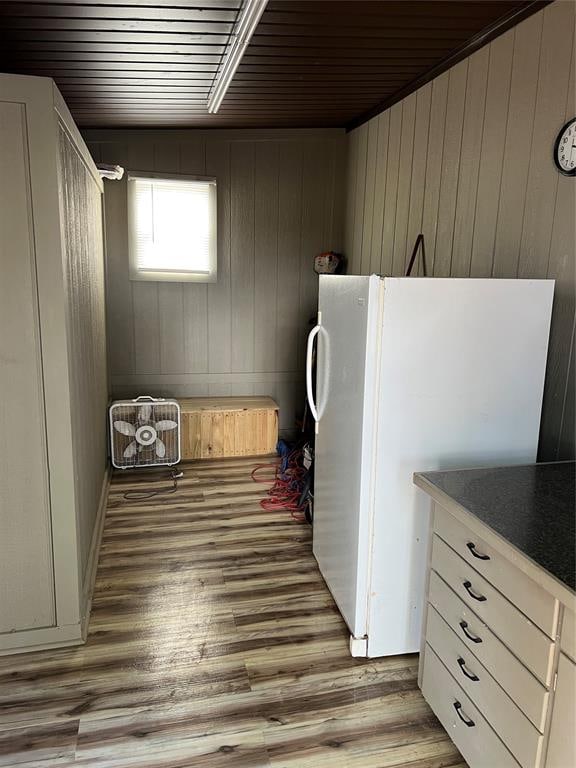 washroom featuring wooden walls, light hardwood / wood-style floors, and wooden ceiling