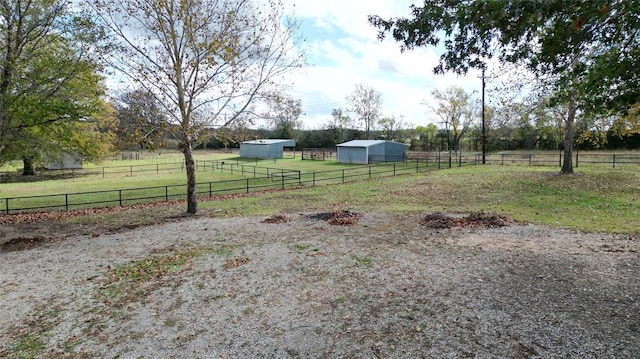 view of yard with a rural view and an outdoor structure