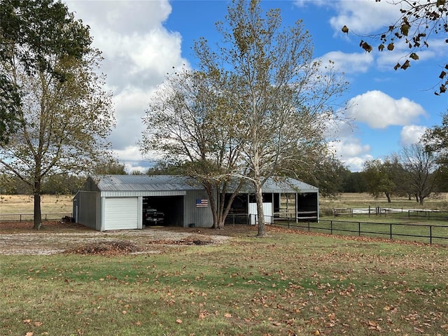 view of front of home with a rural view, a front lawn, and an outdoor structure