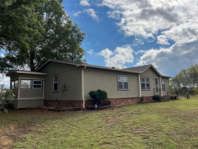 view of side of home with a yard