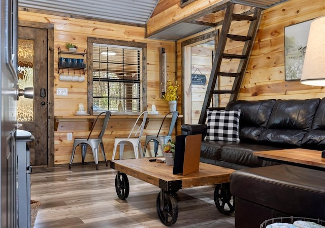 interior space featuring hardwood / wood-style floors, wood walls, and lofted ceiling