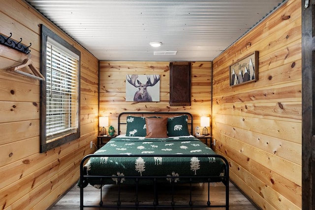 bedroom featuring wood-type flooring and wood walls