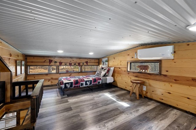 bedroom with dark hardwood / wood-style floors, wood walls, a wall unit AC, and vaulted ceiling