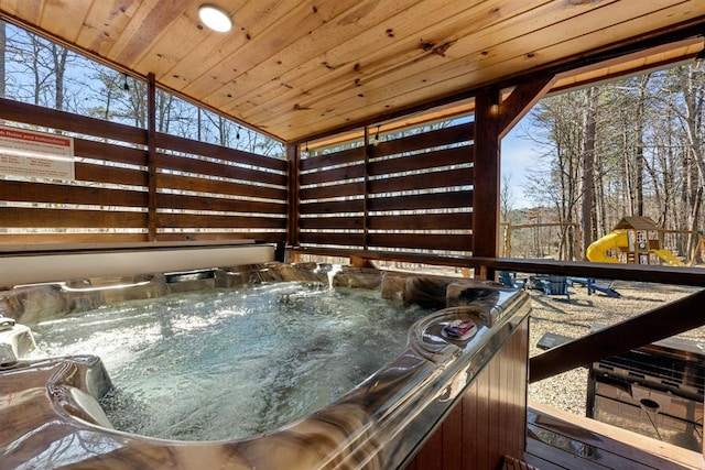 wooden terrace with a playground and a hot tub