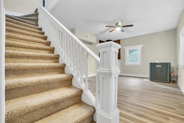 stairs featuring hardwood / wood-style floors, decorative columns, and ceiling fan