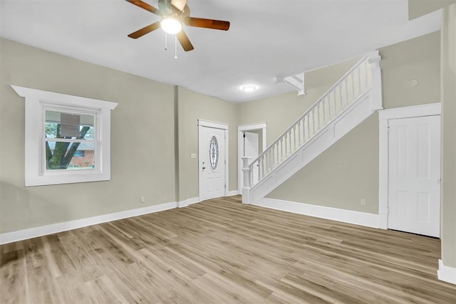 foyer entrance with ceiling fan and light wood-type flooring