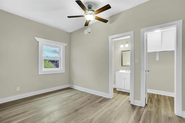 unfurnished bedroom featuring a closet, ceiling fan, ensuite bathroom, and light hardwood / wood-style floors