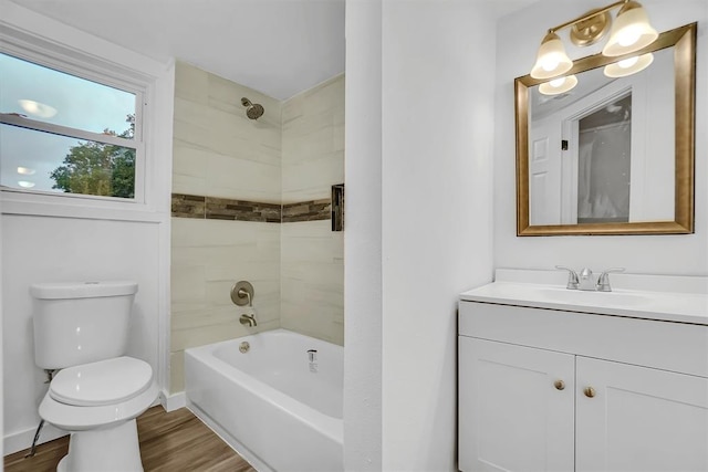 full bathroom with hardwood / wood-style flooring, tiled shower / bath combo, toilet, and vanity