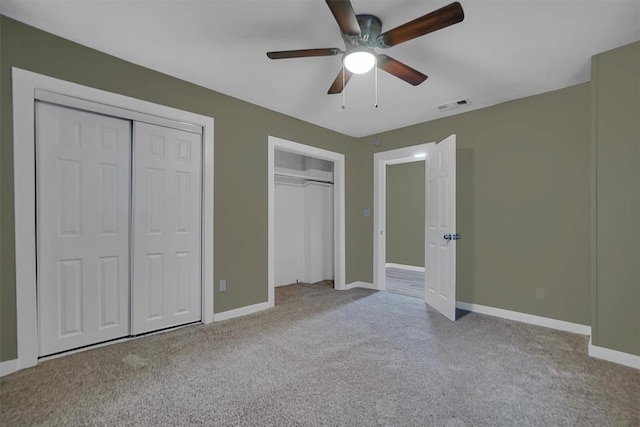 unfurnished bedroom featuring multiple closets, ceiling fan, and light colored carpet