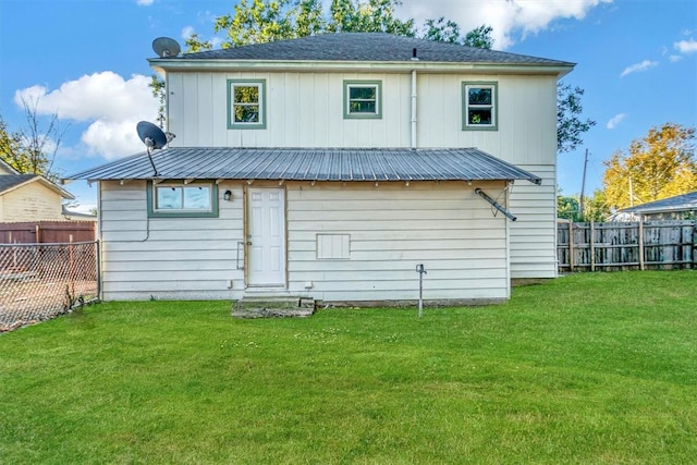 rear view of property featuring a lawn