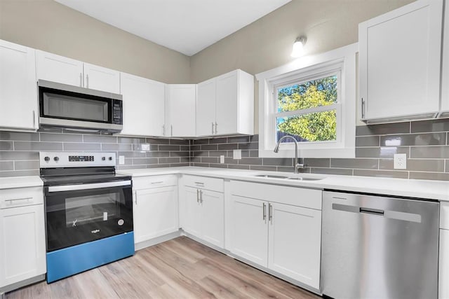 kitchen featuring sink, stainless steel appliances, light hardwood / wood-style flooring, backsplash, and white cabinets