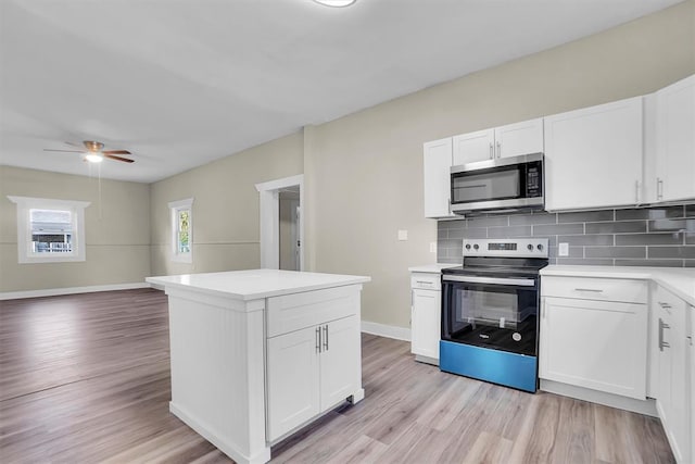 kitchen with tasteful backsplash, white cabinetry, appliances with stainless steel finishes, and light hardwood / wood-style flooring