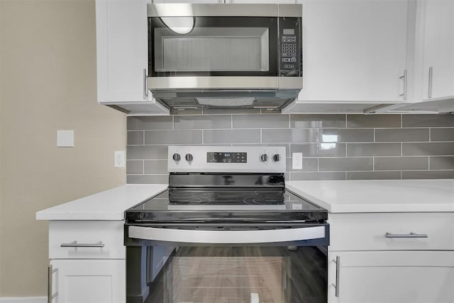 kitchen with backsplash, white cabinetry, and stainless steel appliances