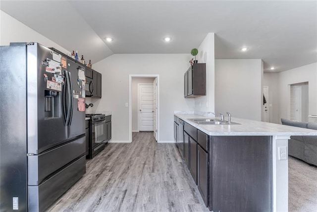 kitchen with black gas range oven, vaulted ceiling, sink, fridge with ice dispenser, and light hardwood / wood-style floors