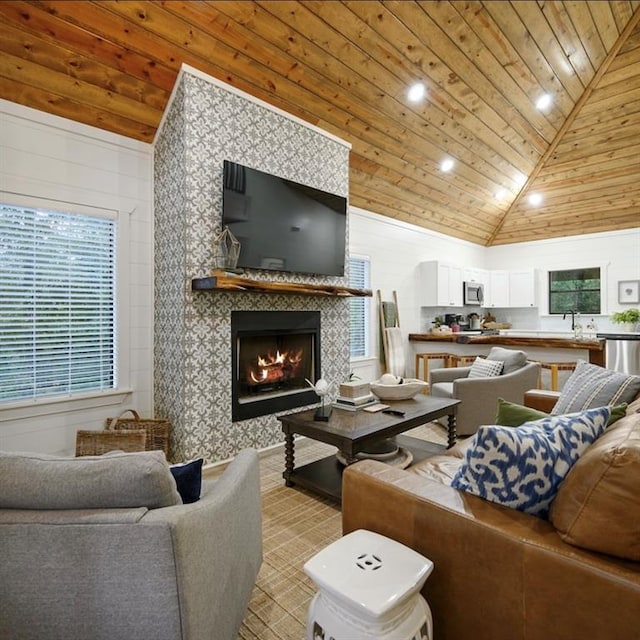 living room with a tiled fireplace, wooden walls, high vaulted ceiling, and wood ceiling