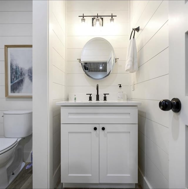 bathroom featuring hardwood / wood-style flooring, vanity, and toilet