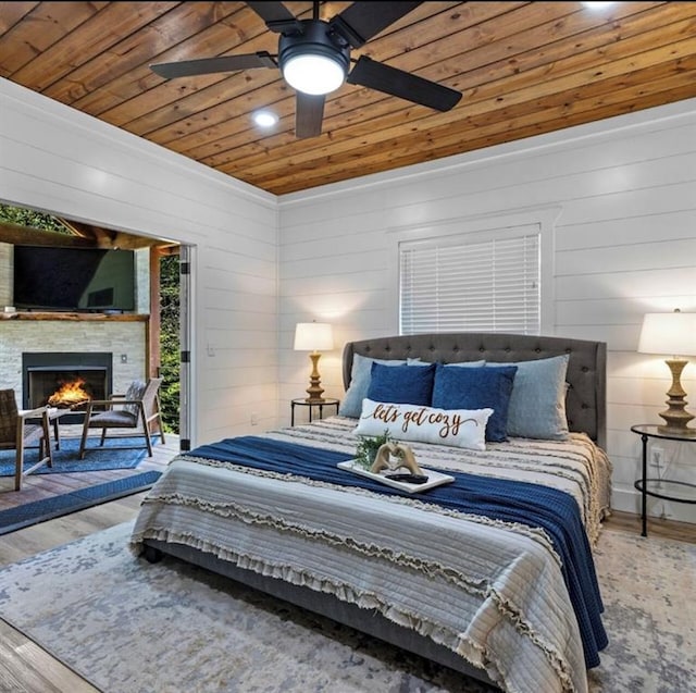 bedroom featuring ceiling fan, wood walls, wood-type flooring, and wood ceiling