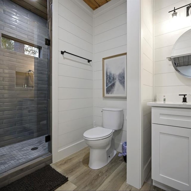 bathroom with hardwood / wood-style flooring, vanity, wood walls, and toilet