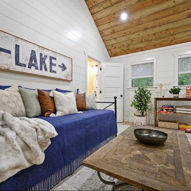 bedroom with wooden ceiling, high vaulted ceiling, and wooden walls