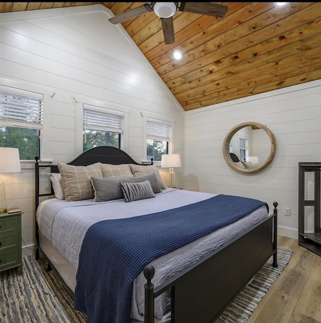 bedroom featuring wood ceiling, ceiling fan, wooden walls, high vaulted ceiling, and hardwood / wood-style floors